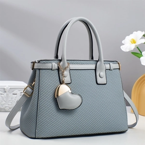 Detail of grey woven texture handbag with heart charm and smooth leather handles