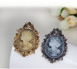 Macro detail of vintage cameo brooches with ornate floral metalwork and sparkling rhinestones