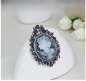 Macro detail of vintage cameo brooch with silver flower frame and black rhinestones