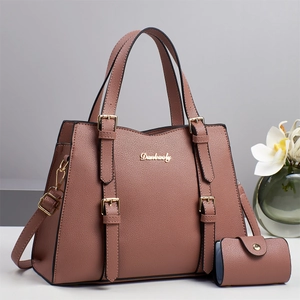 Elegant mauve leather tote bag with decorative belts and matching purse set