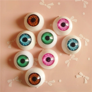 Close-up of 20mm round doll eyes in brown, pink, blue, and green for DIY crafts