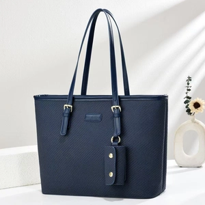 Dettaglio della borsa tote blu scuro intrecciata con manici regolabili e logo