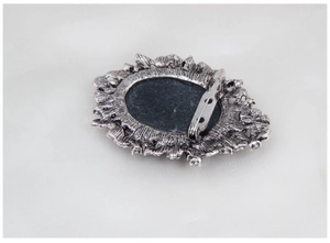 Detail of vintage silver brooch back featuring safe pin and ornate hollowed carving