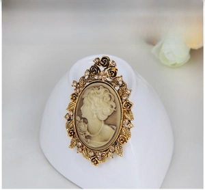 Macro detail of vintage cameo brooch with golden rose petals and champagne rhinestones
