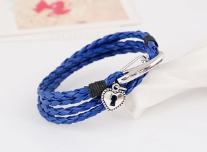 Detail of blue multi-layer braided leather bracelet with silver heart lock charm pendant