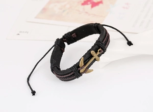 Detail of multi-layer braided leather anchor bracelet with vintage bronze charm