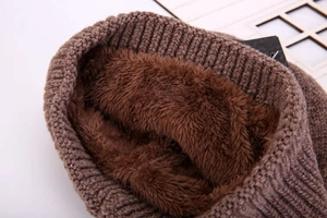 Detailed close-up of brown knit hat showing thick faux shearling lining for winter warmth