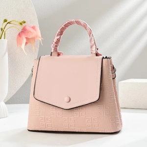 Detailed macro view of pink embossed crossbody bag with decorative floral silk scarf handle