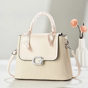 Detail showing beige embossed leather texture, G-letter buckle, and silk scarf handle