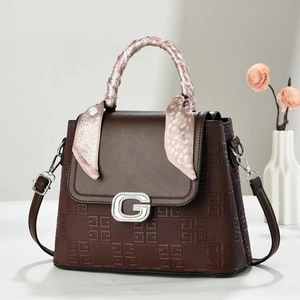 Brown embossed crossbody bag with silver G-buckle and floral silk scarf detail