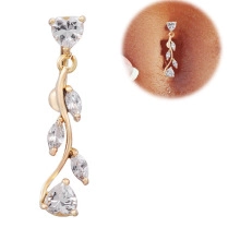 Macro shot of gold belly button ring with heart crystal and dangling leaf stones
