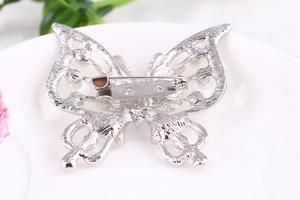 Macro view of the silver alloy butterfly brooch back showing the metal pin closure