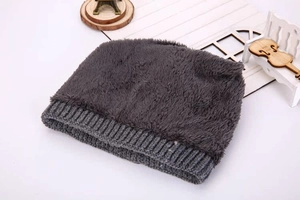 Detail of warm dark gray knitted hat with thick faux fleece lining for winter insulation