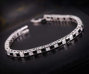 Détail d'un bracelet tennis en argent avec zircons carrés alternant blanc et noir