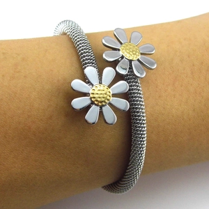 Detail of mesh chain bracelet featuring dual silver daisy motifs with gold-tone centers