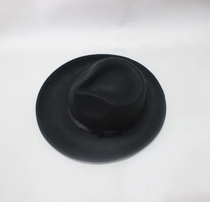 Close-up of a wide-brimmed wool jazz hat featuring a black silk ribbon and bow detail