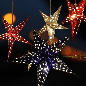 Hanging laser-cut paper star lanterns with moon patterns for Christmas decoration