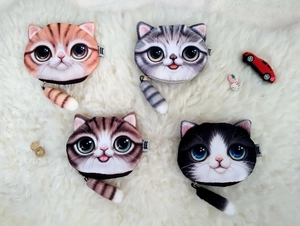 Close-up of four 3D printed cat head coin purses with fluffy tail zippers on fur