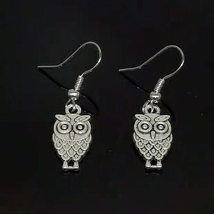 Detailed close-up of vintage silver alloy owl earrings with embossed relief design
