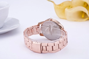 Detail view of rose gold watch case back and stainless steel band with floral decor
