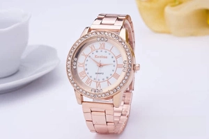 Detail of rose gold quartz watch with rhinestone bezel and Roman numeral dial
