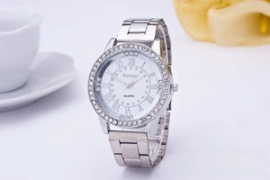 Detailed view of women's silver quartz watch with rhinestone bezel and Roman numerals