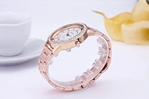 Detail view of rose gold quartz watch with a sparkling diamond bezel and link bracelet
