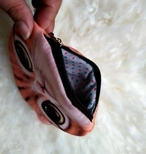 Detail of cute orange cat coin purse with soft fabric and polka dot lining inside