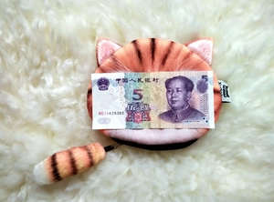 Detailed plush cat coin purse with orange striped fur and fluffy tail charm on white background