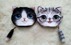 Detail of 3D cat coin purses with plush tails and realistic print on soft white background