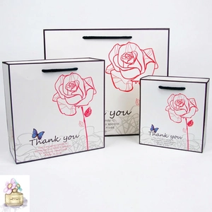 Three sizes of white paper gift bags with red rose design and Thank You text