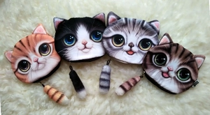 Detail of four 3D printed cat plush coin purses with creative tail zipper pulls