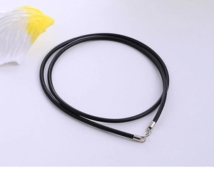 Detail of minimalist black rubber cord necklace with polished silver lobster clasp closure