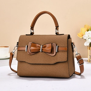 Brown woven square bag with leather bow decoration and detachable shoulder strap