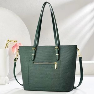 Dettaglio borsa tote verde scuro con trama diagonale e finiture metalliche dorate lucide