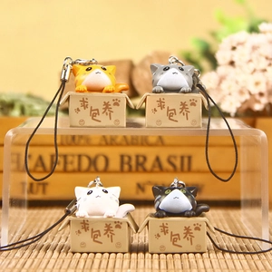 Macro view of four 3D plastic cat charms in boxes with braided lanyards and metal rings