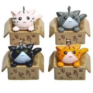 Macro detail of four cute 3D cartoon cats in small boxes as keychain charms