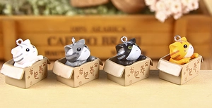 Detail of four colorful 3D cat charms in boxes with metal keyrings and warm aesthetic