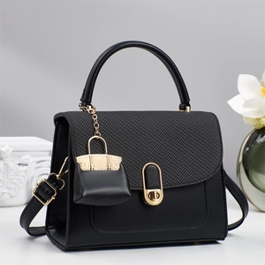 Sac à main élégant en cuir noir avec rabat tressé et fermoir doré dans un décor chic
