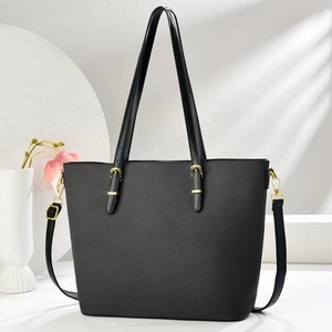 Dettaglio borsa shopper nera con trama intrecciata a rombi e fibbie dorate lucide