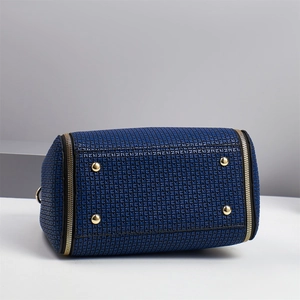 Detail view of the blue Boston bag bottom with four protective gold metal feet studs