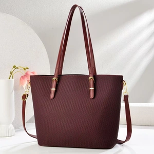 Dettaglio borsa tote bordeaux testurizzata con finiture dorate e tracolla regolabile