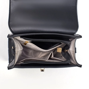 Vue détaillée de l'intérieur du sac en cuir noir avec compartiments multiples et finitions dorées