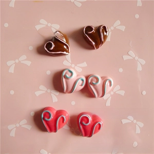 Flat lay of colorful resin heart charms with swirl details for DIY phone case crafts
