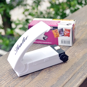 Close-up of a white portable mini heat sealer for plastic bags with Sealer branding