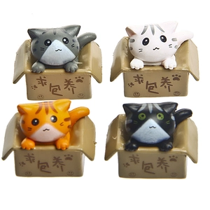 Macro detail of four cute 3D cartoon cats in miniature cardboard boxes for keychains