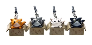Macro view of four 3D cartoon cat headphone dust plugs in miniature cardboard boxes