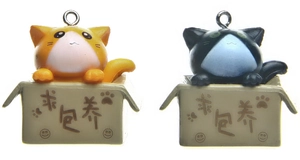 Close-up of cute 3D orange and black cartoon cats in cardboard boxes for keychains