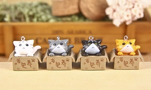 Detail view of four cute 3D cartoon cats in cardboard boxes with keychains