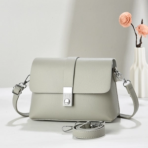 Close-up of light green lychee pattern leather texture with silver metal square buckle
